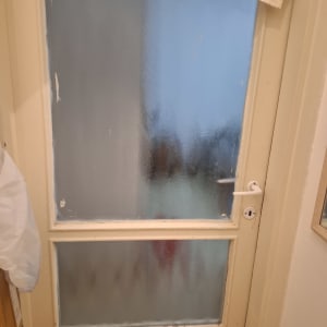 חלון עץ ממוסגר עם זכוכית מחוספסת אטומה לאחר החלפה או תיקון
