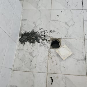 רצפה עם חור פתוח ואריחים שבורים, עבודה בתחום האינסטלציה