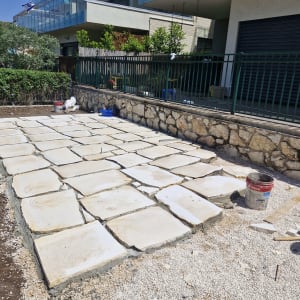 אבנים מרוצפות בגינה עם דליים וכלי עבודה