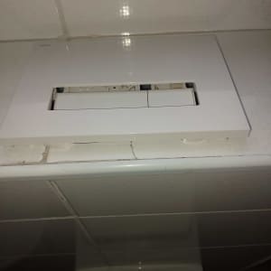 לחצן להדחת אסלה עם אריחים מסביב