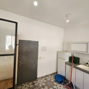 כלי ניקוי ומטאטא ליד קיר צבוע