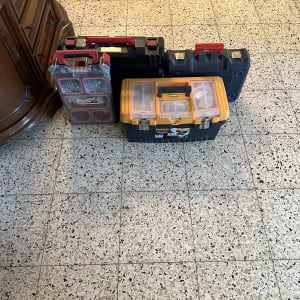 ארבעה ארגזי כלים עם ידיות אדומות על רצפה