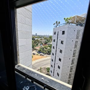 רשת יונים מותקנת על חלון בניין גבוה