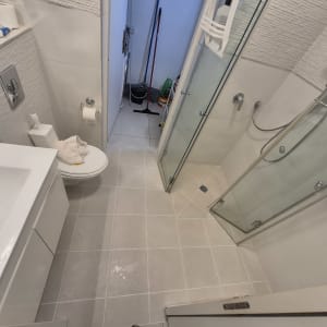 חדר אמבטיה עם מקלחת וכלים לניקוי