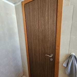דלת עץ עם ידית מתכת בחדר אמבטיה