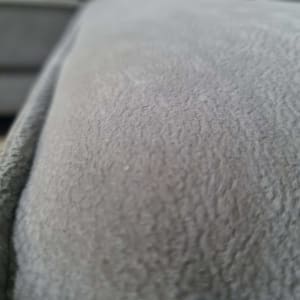 תקריב של ספה אפורה עם כרית צהובה ברקע