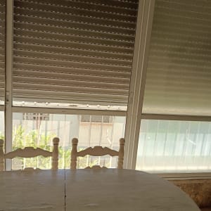 תריסים סגורים ליד שולחן וכיסאות