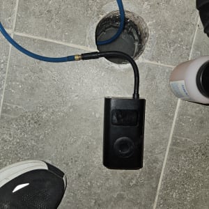 כלי עבודה וצינור כחול ליד חור ברצפה