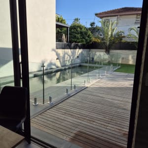 גדר זכוכית סביב בריכה בחצר בית