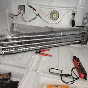 תיקון מקרר עם כלים וחלקים פנימיים גלויים