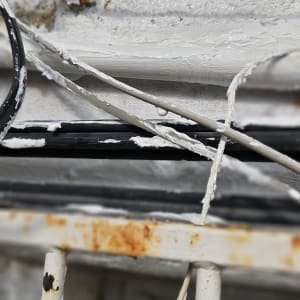 חוטים וצינורות עם חומר איטום לבן על קיר חיצוני