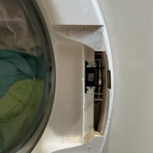 דלת מכונת כביסה עם בגדים בפנים