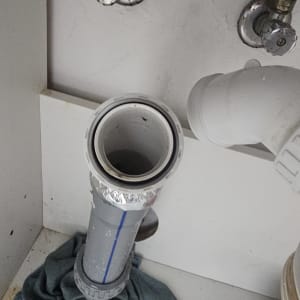 צנרת מתחת לכיור עם ברזים וצינור