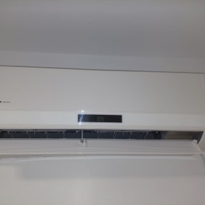 מזגן קיר לבן עם תצוגת טמפרטורה