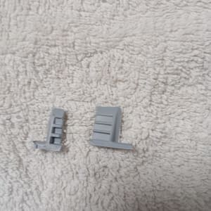 שני חלקי פלסטיק אפורים על רקע בד לבן