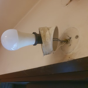 מנורה מותקנת על קיר עם חוטים חשופים