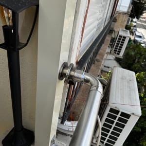 צינור מתכת ליד מזגן על קיר חיצוני