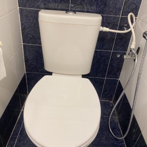 אסלה עם מיכל הדחה וצינור מים