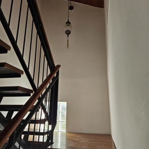 מדרגות עץ עם מעקה מתכת, קיר צבוע ולבני זכוכית.