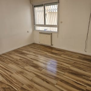 חדר ריק עם רצפת עץ נקייה ומזגן על הקיר