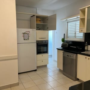 מטבח עם ארונות פתוחים, תנור ומדיח כלים