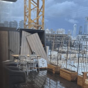 מרפסת עם ריהוט חוץ ועבודות בנייה ברקע