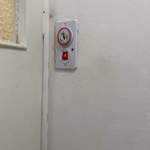 טיימר חשמלי עם מתג על קיר לבן