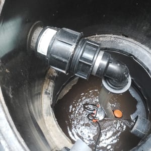 צינור פלסטיק מחובר למערכת ניקוז עם מים