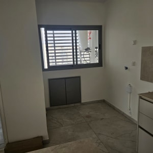 מטבח ריק עם חלון ודלת פתוחה