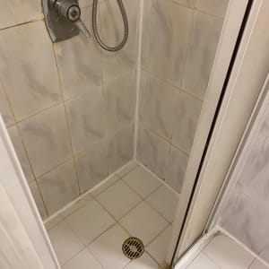 מקלחת עם ברז, צינור ניקוז ורצפת אריחים