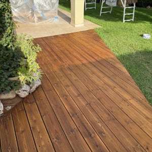 דק עץ בגינה עם רהיטים מכוסים בניילון