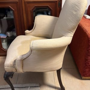 כיסא עם כתם על המושב, ליד שטיח פסים