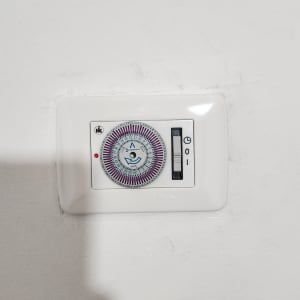 שעון טיימר חשמלי מותקן על קיר לבן