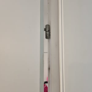 ציר מתכת בדלת לבנה פתוחה מעט