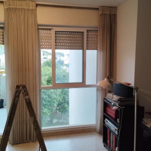 תריסים חומים סגורים על חלון זכוכית גדול