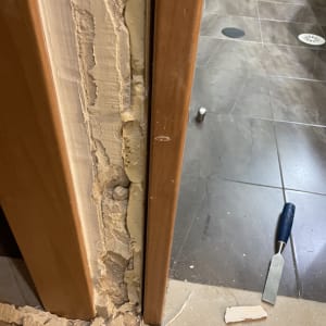 משקוף דלת עם טיח מתקלף וכלי עבודה על הרצפה