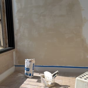 קיר בתהליך שיפוץ עם כלי עבודה וחומרי בנייה