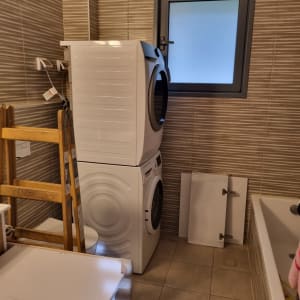 סולם עץ ליד מכונת כביסה בחדר אמבטיה