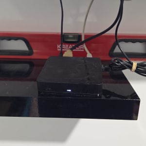 מדף שחור עם מכשיר אלקטרוני ומפלס בנייה אדום