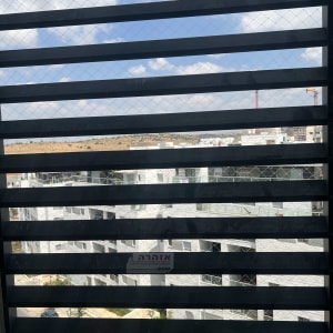 רשת מתכת על חלון למניעת כניסת יונים