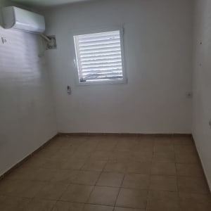 חדר ריק עם קירות לבנים ורצפת אריחים