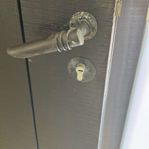 ידית ומנעול צילינדר מותקנים על דלת עץ כהה