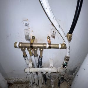 צינורות מים ומחברים על קיר לבן