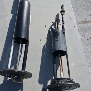 שני חלקים מתכתיים על משטח, אחד חדש ואחד חלוד