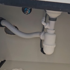 צנרת מתחת לכיור עם מחבר פלסטיק לבן