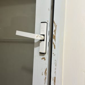 ידית חלון לבנה על מסגרת מתכת