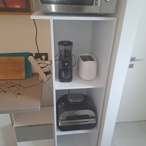 מיקרוגל, טוסטר ומכונת קפה על מדף במטבח.