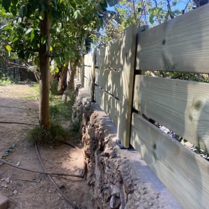 גדר עץ חדשה ליד עץ בגינה