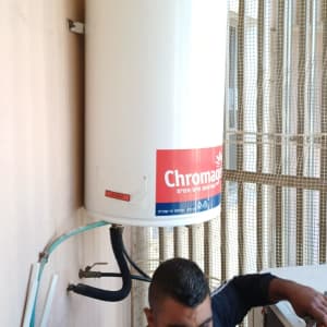 טכנאי מתקין דוד שמש על קיר חיצוני