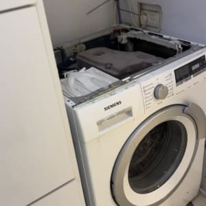 תיקון מכונת כביסה פתח חזית סטנדרטית במהלך פירוק מכסה עליון